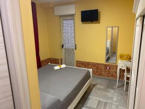 ein kleines Schlafzimmer mit einem Bett und einem Spiegel in der Unterkunft Residenza Manfredi in Potenza