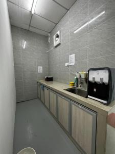 uma cozinha com um lavatório e uma bancada em Jiaxin Dormitory-Setia Indah 家馨青年旅宿 em Johor Bahru