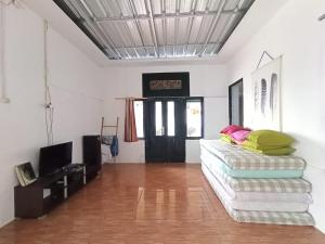 a living room with a couch and a tv at Villa Cisarua Kerucut in Brujul