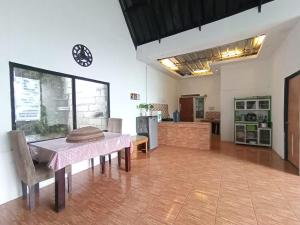 a dining room with a table and a kitchen at Villa Cisarua Kerucut in Brujul