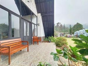 two benches sitting outside of a building at Villa Cisarua Kerucut in Brujul