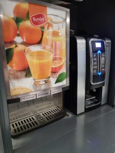 una cafetera con un vaso de líquido naranja en Brit Hotel La Bonne Etape, en Évreux