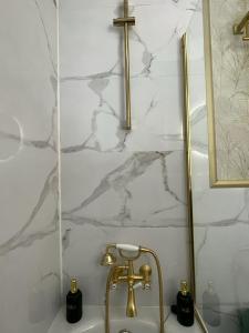 a sink with a gold faucet and a cross on a wall at El Balcón de Fuenteheridos in Fuenteheridos