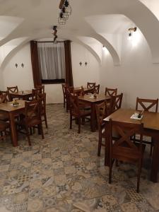 a dining room with wooden tables and chairs at Penzion Kotva in Klatovy