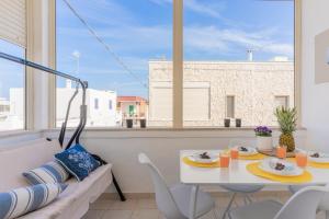 a dining room with a table and chairs and a window at Casa Olimpo vicino alle spiagge di sabbia in Specchiolla 