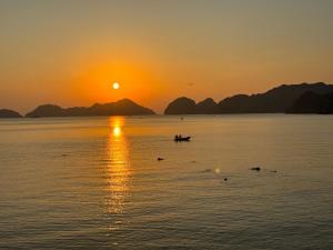 a boat in the water at sunset at Phoenix Flower Hotel in Cat Ba