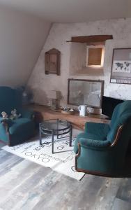 a living room with two chairs and a table at Val de Gée à 20 mn du circuit 24 h du Mans in Maigné