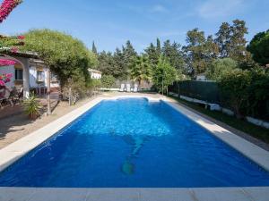 een zwembad met blauw water in een tuin bij Holiday Home Hanna - CHZ300 by Interhome in Chiclana de la Frontera