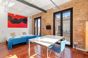 a living room with a white table and blue chairs at AB Paral-lel Tapioles in Barcelona