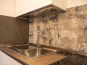 a kitchen with a stainless steel sink and a wall with graffiti at La Premiere Suite - Teatro Massimo Palermo in Palermo +26 photos