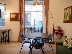 a living room with a table and chairs and a window at La Premiere Suite - Teatro Massimo Palermo in Palermo