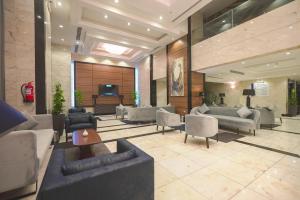 a lobby with couches and chairs and a television at La Cordia Hotel Apartment in Al Madinah
