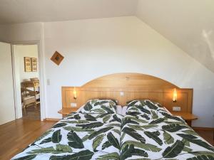 Un dormitorio con una cama con un edredón verde y blanco. en Apartment Schwarzwaldblick III by Interhome, en Bernau im Schwarzwald