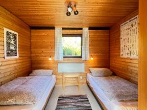 - 2 lits dans une chambre dotée de murs en bois dans l'établissement Holiday Home Rechbergblick - BEU302 by Interhome, à Bernau im Schwarzwald