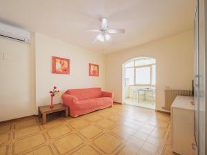a living room with a red couch and a table at Apartment Dei Fiori by Interhome in Lido di Camaiore +34 photos