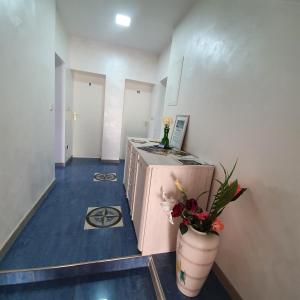 a room with a counter and a vase with flowers in it at Pension Bad Soden / Apartment and Rooms in Bad Soden am Taunus