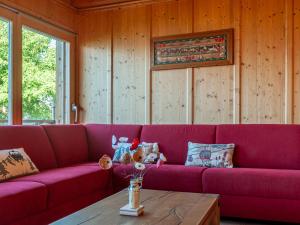ナンダにあるChalet Rêves des Alpes by Interhomeの木製の壁の客室内のピンクのソファ