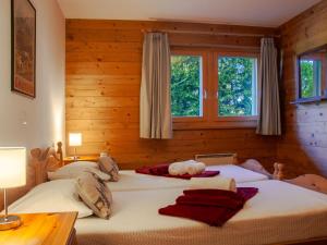 two beds in a bedroom with two windows at Chalet Rêves des Alpes by Interhome in Nendaz