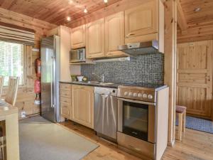 cocina con armarios de madera y estufa de acero inoxidable en Holiday Home Kannelpirtti 2 by Interhome, en Puromäki 20 fotos más