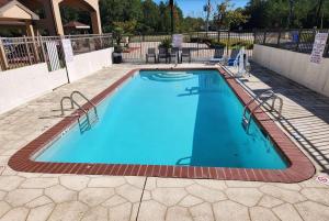 a large swimming pool with blue water in a yard at Days Inn by Wyndham Lumberton in Lumberton