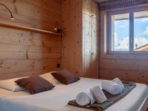 ein Schlafzimmer mit einem Bett mit zwei Kissen und einem Fenster in der Unterkunft Chalet Chalet Jadi by Interhome in Nendaz