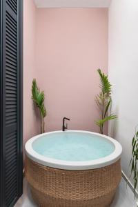 a bath tub in a bathroom with two plants at The Alma City Hotel in Chania