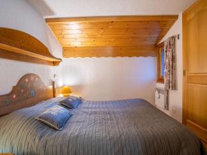 a bedroom with a large bed with blue pillows at Apartment Les Hauts des Chavants - by Interhome in Les Houches