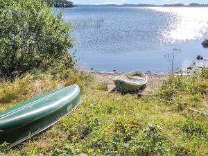 dois barcos sentados na margem de um lago em Holiday Home Kolin mesikämmen by Interhome em Kolinkylä