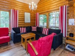 un soggiorno con divano nero e sedie rosse di Holiday Home Purnuranta c by Interhome a Kolinkylä