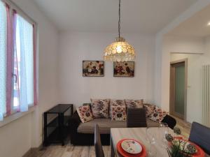 un soggiorno con divano e lampadario pendente di Apartment Letizia - DGO232 by Interhome a Dongo