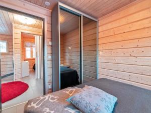 ユッラスヤルヴィにあるHoliday Home White dream a by Interhomeの木造キャビン内のベッド1台が備わるベッドルーム1室を利用します。