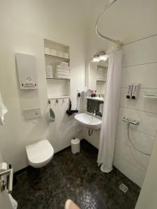 biała łazienka z toaletą i umywalką w obiekcie Apartment 229 w Dortmundzie