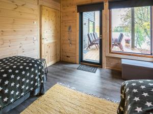 Habitación con cama y terraza con sillas. en Holiday Home Villa kurki by Interhome en Torvoila