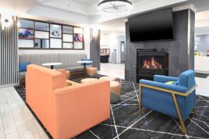 a lobby with couches and a fireplace and a tv at Hampton Inn Bryant in Bryant