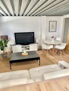 - un salon avec un canapé blanc et une table dans l'établissement Loft Alameda en Sevilla, à Séville