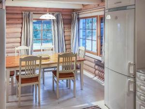 uma cozinha e sala de jantar com uma mesa de madeira e cadeiras em Holiday Home Päivärinne by Interhome em Mäkisauru