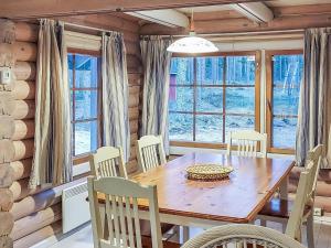 een eetkamer met een houten tafel en stoelen bij Holiday Home Päivärinne by Interhome in Mäkisauru