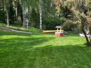 Holiday Home Lomaranta by Interhome في Paksalo: حديقة فيها زحليقة صفراء في العشب