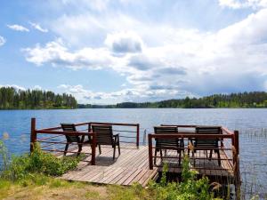 a dock with chairs and tables on a lake at Holiday Home Ukko-metso by Interhome in Rahula