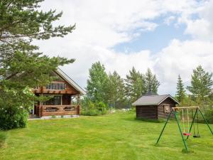 a yard with a log cabin and a swing at Holiday Home Ranta-lemettilä by Interhome in Petäjävesi