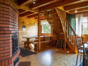 a room with a fireplace and a table in a cabin at Holiday Home Ranta-lemettilä by Interhome in Petäjävesi