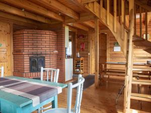 a wooden cabin with a table and a fireplace at Holiday Home Ranta-lemettilä by Interhome in Petäjävesi