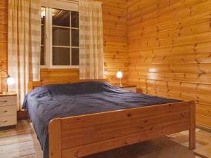 a bedroom with a bed in a log cabin at Holiday Home Kivikko by Interhome in Laitikkala