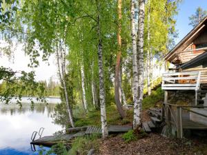 a cabin in the woods next to a lake at Holiday Home Havukka by Interhome in Visulahti