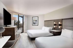 Habitación de hotel con 2 camas y TV de pantalla plana. en Hilton Galveston Island Resort, en Galveston