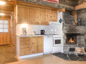 a kitchen with a stove and a fireplace at Holiday Home Tokkapirtti 3 by Interhome in Sirkka