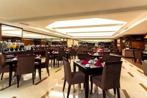 a dining room with tables and chairs in a restaurant at Best Western Mangga Dua Hotel & Residence in Jakarta