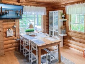 Holiday Home Vastaniemi by Interhome في Paloinen: غرفة طعام مع طاولة وتلفزيون في كابينة خشبية