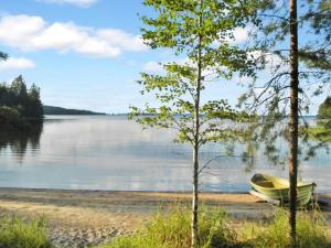 un bateau assis sur la rive d'un lac dans l'établissement Holiday Home Maunonlahti by Interhome, à Hattusaari