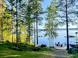 a view of a lake with a table and a bench at Holiday Home Rantakumpu by Interhome in Lieksa